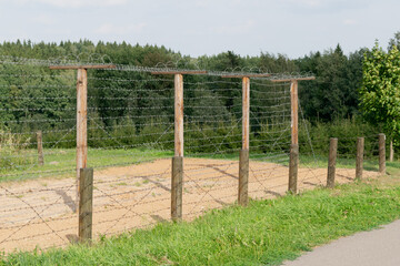 Fototapeta na wymiar Model of a wooden fence with barbed wire along the perimeter of the protected area.