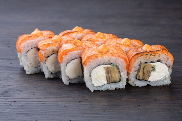 traditional Japanese sushi with salmon, soft cheese, avocado and red caviar, garnished with creamy sauce. Japanese kitchen. Japanese restaurant.