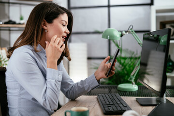 Businesswoman using the phone in office. Beautiful young woman waiting for phone call.