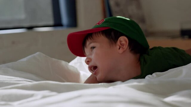 Toddler boy watching tv on saturday morning in parents bed - funny reactions