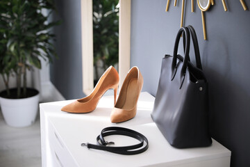 Stylish women's shoes, belt and bag in modern boutique