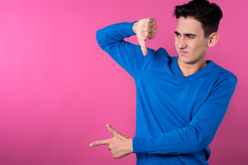 A young man gestures with his hands. Pink background. Consent and denial. Good and bad.