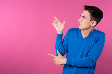 A young man gestures with his hands. Pink background. Consent and denial. Good and bad.