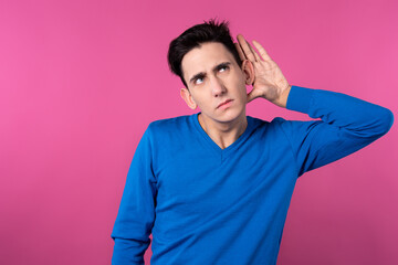 Handsome guy ponders. Think and decide. Pink background. Problem.