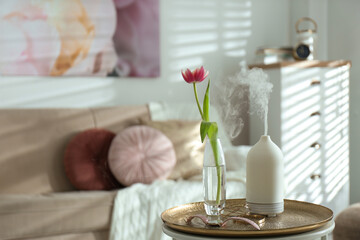 Aroma oil diffuser, tulip in vase and accessories on table indoors. Space for text