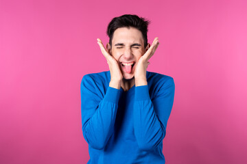 A young man gestures with his hands. Pink background. Consent and denial. Good and bad.