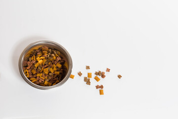 Dry food in an iron bowl on a white background.