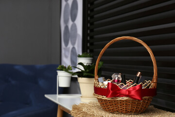 Fototapeta na wymiar Wicker gift basket with cosmetic products on table indoors