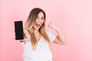 Naklejka premium a young blonde woman shows her cell phone with a raised fist