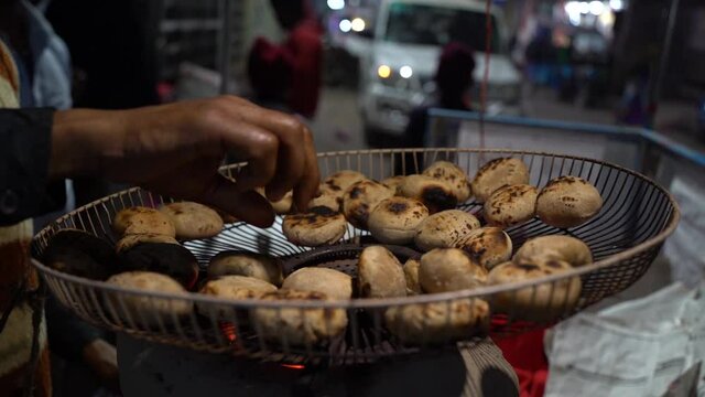 A slow-motion clip of a hand flipping the hot Litti food of the Bihar State of India in HD
