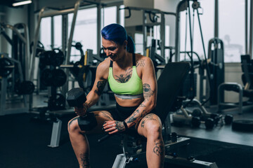 tattooed woman workout in gym