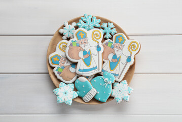 Tasty gingerbread cookies on white wooden table, top view. St. Nicholas Day celebration