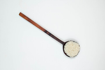 A wooden spoon of long grain white rice, isolated on white background. Copy space