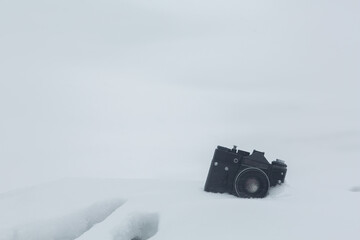 Photo camera in the snow. Camera and snow. 
