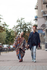 Vertical photo, red-haired guy and girl in unusual clothes, couple in love on the street