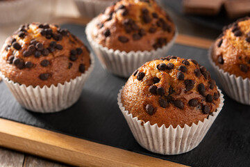 Just baked chocolate muffins on rustic wooden table