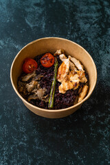 Healthy Food Bowl with Chicken, Black Rice or Wild Rice, Asparagus Mushroom, Avocado Mash and Roasted Grilled Tomatoes in Plastic Take Away Bowl