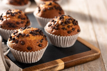 Just baked chocolate muffins on rustic wooden table