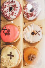 Assorted tasty colorful donuts on display, close up view. Street food market