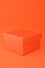 Orange cardboard box with a background of the same color.