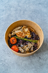 Healthy Food Bowl with Chicken, Black Rice or Wild Rice, Asparagus Mushroom, Avocado Mash and Roasted Grilled Tomatoes in Plastic Take Away Bowl