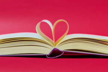 Pages of a book curved into a heart shape. Opened book, pages shaped to form a heart