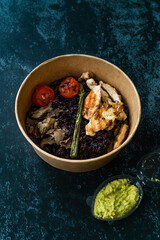 Healthy Food Bowl with Chicken, Black Rice or Wild Rice, Asparagus Mushroom, Avocado Mash and Roasted Grilled Tomatoes in Plastic Take Away Bowl
