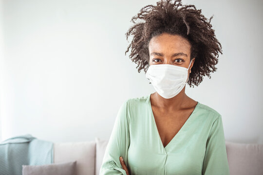 Masked woman - protection against influenza virus. African - American woman wearing mask for protect. Woman wear with protective face mask at home. Stop the virus and epidemic diseases.