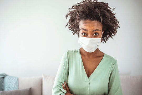 Masked woman - protection against influenza virus. African - American woman wearing mask for protect. Woman wear with protective face mask at home. Stop the virus and epidemic diseases.