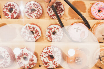 Assorted tasty colorful donuts on display, close up view. Street food market