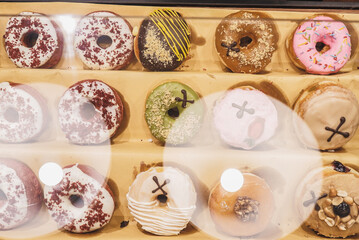 Assorted tasty colorful donuts on display, close up view. Street food market