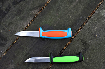 Comparison of two knives. Two multi-colored knives. Flat lay.