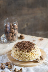 Traditional Russian anthill cake decorated with chocolate on light wooden background. Selective focus, vertical orientation, copyspace