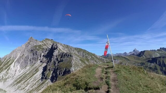 windsock with paraglider pilot in the wind on a perfect summer day, blue sky. Location Loser Alm in Salzburger Land, austria