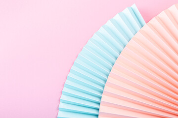Colorful abstract background with paper fans, multicolored, light blue, pink and beige. Trend Concept. Top view, close up. Copy space