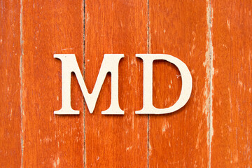 Alphabet letter in  word MD (abbreviation of doctor of medicine or managing director) on old red color wood plate background