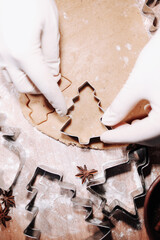 Woman cutting some gingerbread dough with a metal cookie cutter