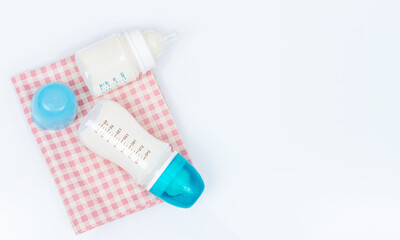 Feeding bottles of baby formula with powder and pacifier on white background
