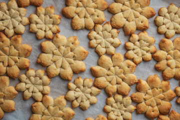 Close-up Christmas snowflakes gingerbread cookies on baking sheet. New Year and Christmas celebration concept. Soft focus.