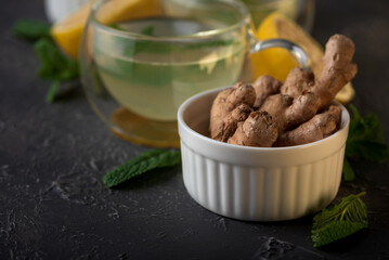 Ginger tea with mint, lemon and honey on concrete background.