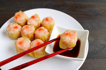Shrimp and Pork Filled Chinese Steamed Dumpling Being Dipped in Soy-vinegar Sauce