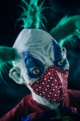 disturbing evil clown wears a red face mask