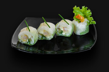 freshly made Japanese sushi rolls served on a black stone slab