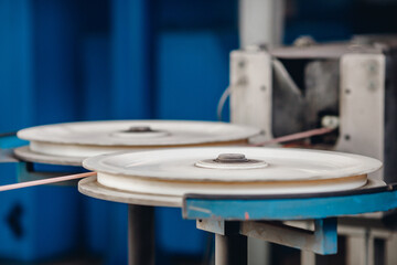 Fototapeta na wymiar Production of copper wire, bronze cable in reels at factory