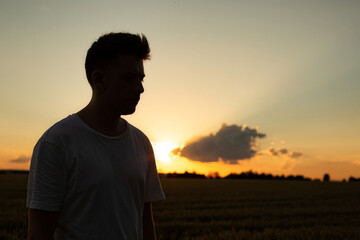 White european boy with sky behind in sunset shadow