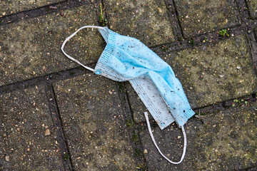 Used medical mask on street ground