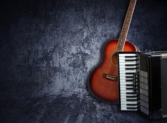 Acoustic guitar and accordion on a dark grunge background. Place for inscription - obrazy, fototapety, plakaty