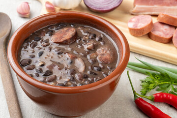 Traditional brazilian feijoada in a bowl with ingredients