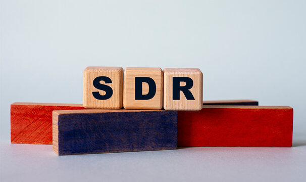 SDR - acronym on wooden cubes on a background of colored block on a light background
