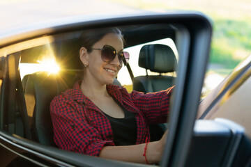 beautiful woman driving and smiling. portrait of happy girl in the car. traveling. enjoying the life
